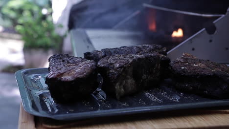 Filetes-Gruesos-Y-Jugosos-De-Filet-Mignon-Fumando-En-Una-Parrilla-Al-Aire-Libre-En-El-Patio-Trasero,-Cerca-De-La-Profundidad-De-Campo