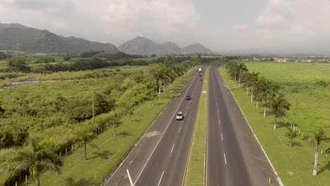 Aerial-Dolly-In-Shot-Cars-Driving-on-CA2-Highway-in-Guatemala-Volcan-of-Pacaya-in-Background