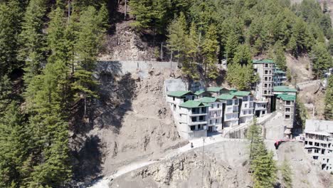 Edificios-Modernos-Construidos-En-Una-Empinada-Ladera-De-Montaña-Rodeada-De-Densos-Bosques-De-Pinos.