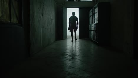 Back-view-young-shirtless-muscular-Caucasian-man-hitting-locker-with-his-fist,-tired-and-upset-after-failure-in-gym