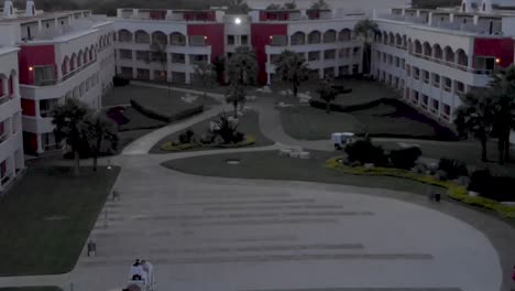 An-aerial-reveal-of-a-horse-and-carriage-riding-through-the-courtyard-of-a-grand-resort-in-Mexico
