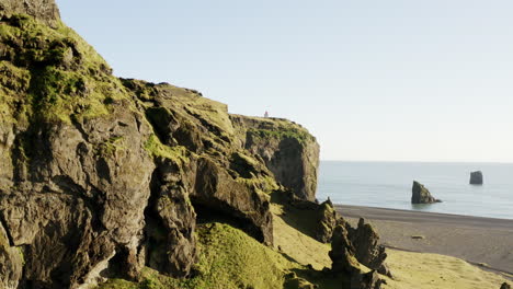 Slow-revealing-drone-shot-of-a-lighthouse-on-a-seaside-cliff-in-Iceland