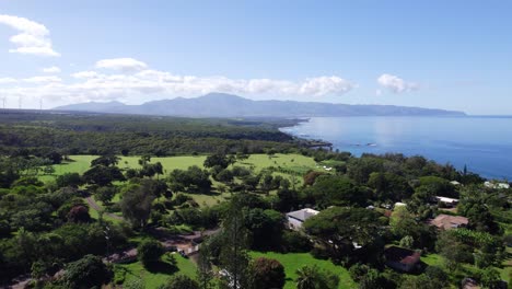 Drone-footage-across-the-North-Shore-area-of-Oahu-Hawaii-from-the-treetops-to-the-open-grassy-areas-that-line-the-coast-of-this-Hawaiian-island-with-mountains-on-the-horizon