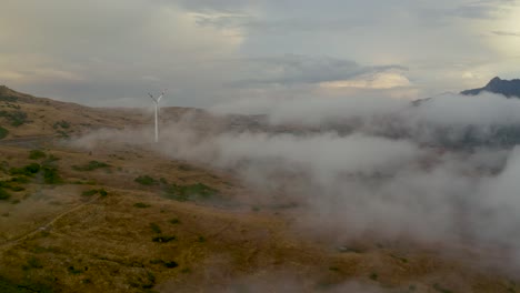 Ein-Spektakuläres-Bild-Einer-Drohne,-Die-Bei-Sonnenuntergang-Durch-Die-Wolken-Auf-Eine-Windturbine-In-Der-Sizilianischen-Landschaft-Zufliegt