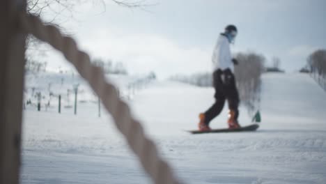 Männlicher-Snowboarder-Erreicht-Das-Ende-Der-Skipiste