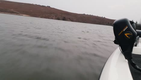 Side-view-of-a-bass-boat-at-high-speed-on-a-lake-on-a-cloudy-day