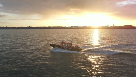 Coastguard-boat-travels-through-calm-water-of-Waddenzee-during-sunrise