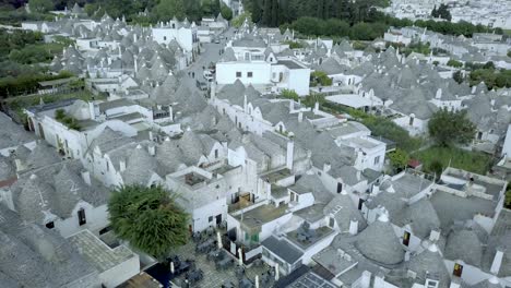 Beautiful-aerial-drone-footage-of-a-fourteenth-to-sixteenth-century-UNESCO-heritage-site-in-Alberobello,-at-the-South-of-Italy-showcasing-the-whitewashed-Trulli-and-their-handmade-symbolic-pinnacles