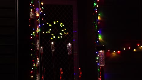 Postes-De-Navidad-Iluminados-Que-Conducen-A-La-Puerta-Principal-Con-Corona-En-La-Noche
