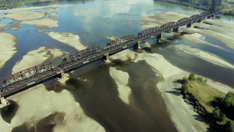 A-moving,-aerial-view-of-a-train-bridge-in-Prince-George,-crossing-the-Fraser-River