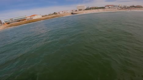 The-surfer's-perspective-through-a-head-cam-as-they-navigate-the-rolling-waves-near-the-coastline,-capturing-the-essence-of-free-time-activities,-sports,-and-fitness-amidst-the-sea