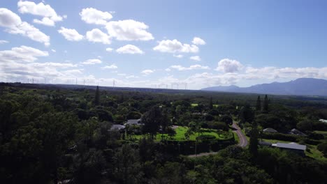 Drone-footage-near-the-North-Shore-of-Oahu-Hawaii-skimming-the-treetops-along-the-lush-green-residential-landscape-and-open-fields