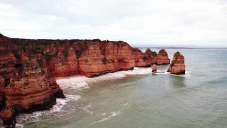 Coastline-with-rugged-cliffs-by-aerial-4k-drone-at-Ponta-da-Piedade-near-Lagos-in-the-Algarve-region-of-Portugal