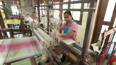 Weaving-a-traditional-Thai-dress-on-an-old-wooden-loom-at-the-Jim-Thompson-Silk-farm-in-Nakhon-Ratchasima-Thailand