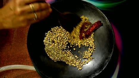 close-up-of-dry-roasting-spices-at-home-on-a-griddle-by-an-indian-woman-at-home