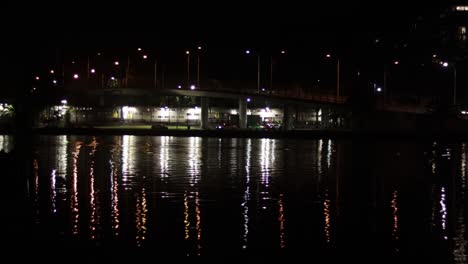 Verkehr-Auf-Der-Brücke-Mit-Lichtreflexion-Auf-Dem-Wasser-Bei-Nacht-In-Echtzeit