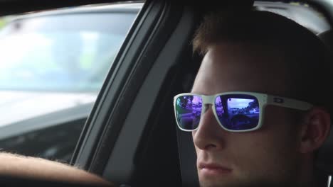 Handsome-Male-with-Sunglasses-Driving-in-Rear-View-Mirror
