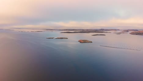 Isolated-small-islands-Located-in-Lysekil,-Sweden-with-cool-and-calm-waters-during-sunset---Aerial-shot
