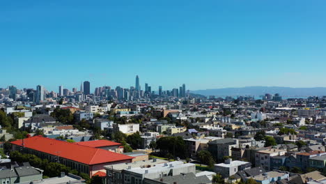 Aerial-view-low-over-the-cityscape,-toward-the-skyline-of-San-Francisco,-USA