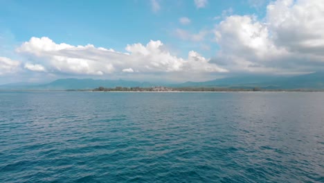 drone-aerial-low-fly-fast-over-tropical-clear-blue-sea-on-small-asian-bali-island-sunny-day