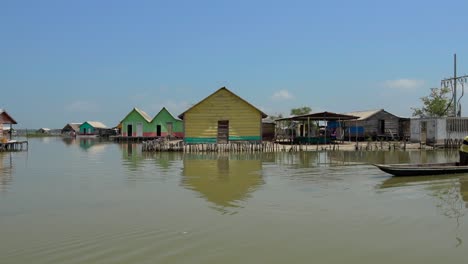 Palafitos-Y-Hombre-En-Canoa-Con-Niños.