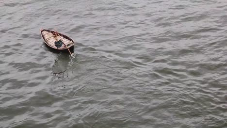 Barquero-Remando-En-Su-Bote-De-Madera-En-El-Río-Buriganga,-Sadarghat,-Dhaka,-Bangladesh