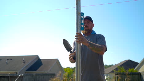 Laborer-checks-a-spirit-level-on-a-metal-pipe