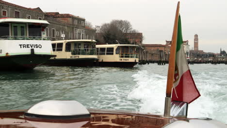 Bandera-Italiana-En-La-Popa-De-Un-Barco-Taxi-Acuático-Privado-Sobre-El-Gran-Canal-De-Venecia,-Italia