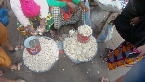 Hands-of-women-selling-baobab-fruit-on-the-street-in-Banjul,-Gambia