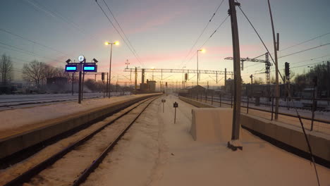 Vista-Estática-De-Un-Patio-De-Trenes-Vacío-Cubierto-De-Nieve-Durante-La-Puesta-De-Sol