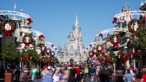 Time-lapse-of-Disney's-Magic-Kingdom-park-goers-experiencing-Main-Street-USA-in-December-with-holiday-decorations-and-Cinderella's-Castle-off-in-the-distance