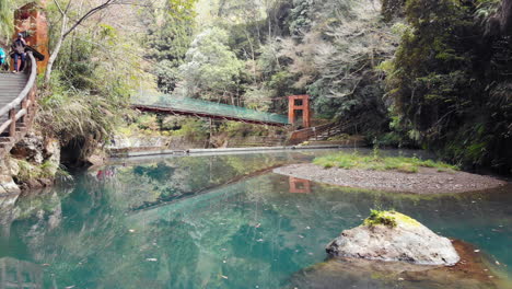 Una-Toma-De-Drone-De-Un-Estanque-Y-Un-Puente-Colgante-Cerca-De-La-Cascada-De-Roca-Songlong-En-El-Mar-Sun-Link,-Taiwán