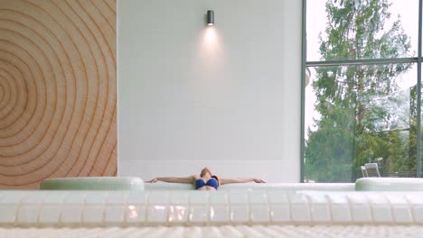 Woman-relaxes-in-hot-tub-with-head-back-in-wellness-resort-spa,-low-angle-slomo