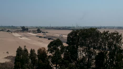 Vista-Aérea-De-Eucaliptos-En-Dunas,-Carreteras-Y-Contaminación-De-Tejidos-Desde-Lejos