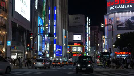 Cars-driving,-pedestrians-and-futuristic-neon-signs-in-Shinjuku,-Tokyo