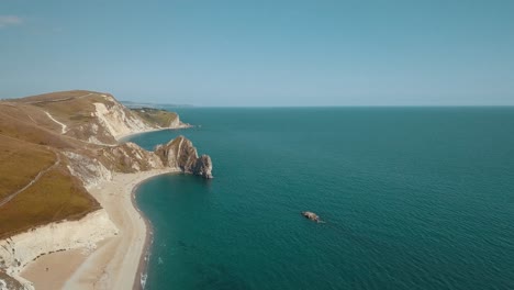 Toma-Aérea-Volando-De-Lado-Sobre-Impresionantes-Acantilados-Hacia-El-Mar-En-La-Costa-Jurásica,-Sur-De-Inglaterra