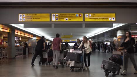 Gente-Caminando-En-El-Aeropuerto-Con-Maletas