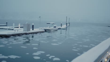 An-early-winter-morning-on-the-Poulsbo-Harbor-during-a-rare-Seattle-snow-storm,-panning-up-to-reveal-a-boat-dock