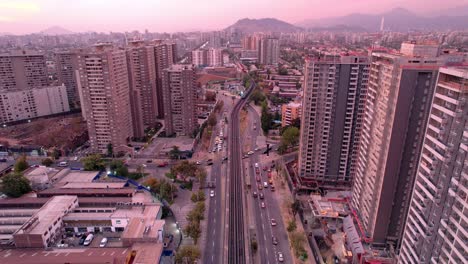 Vicuña-Mackenna-Avenue-Mit-U-Bahnlinie-5-Gleisen-über-Der-Straße-In-Der-Abenddämmerung,-Santiago,-Luftaufnahme