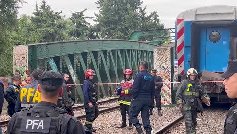 Fire-department-staff-by-crashed-train-on-bridge-in-Argentina,-pan