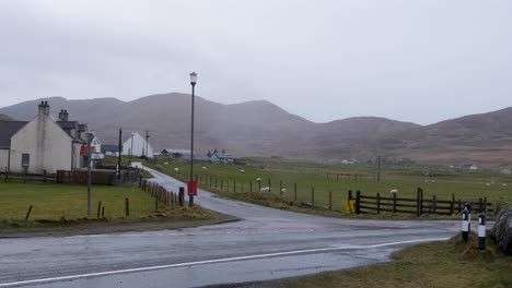 Scenic-landscape-view-of-rural-countryside-with-houses,-letter-box-and-green-fields-with-sheep-on-the-Isle-of-Barra-in-the-Outer-Hebrides-of-Scotland-UK