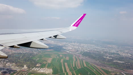 An-aerial-view-of-a-plane-flies-above-a-city-during-take-off