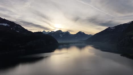 Drone-view-of-beautiful-Sunrise-over-the-Walensee,-Walenstadt,-Weesen,-Quinten,-and-the-Churfirsten-mountains,-Switzerland