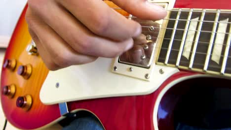 Un-Tipo-Tocando-Y-Rasgueando-Su-Guitarra-Al-Estilo-De-Los-Dedos-En-Una-Habitación