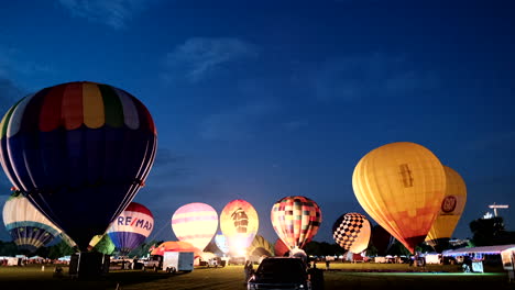 Hot-air-balloons-illuminated-at-dusk-as-they-are-being-inflated