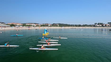 children-with-life-saving-vests-compete-in-rowing-canoe-race-on-the-prepared-circuit-on-the-beach-of-the-tourist-and-holiday-village-a-sunny-morning,-shooting-tracking