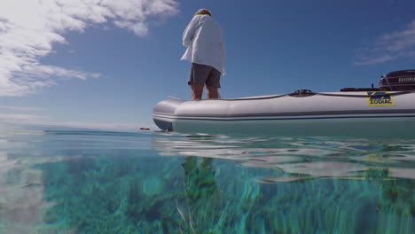 Man-Standing-Paddling-Dinghy-Looking-Around,-Sea-Lagoon-HANDHELD-SLOMO