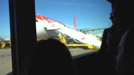 Handheld-footage,-silhouette-of-person-riding-a-bus-with-blurred-EasyJet-aircraft-in-the-background