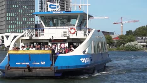 People-on-ferry-in-Amsterdam-Canal,-sunny-day