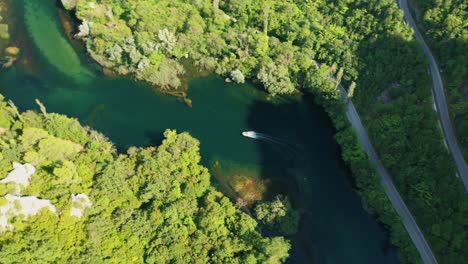 Aerial-drone-footage-following-a-small-fast-boat-on-a-emerald-coloured-river-Cetina-in-Croatia---stock-video